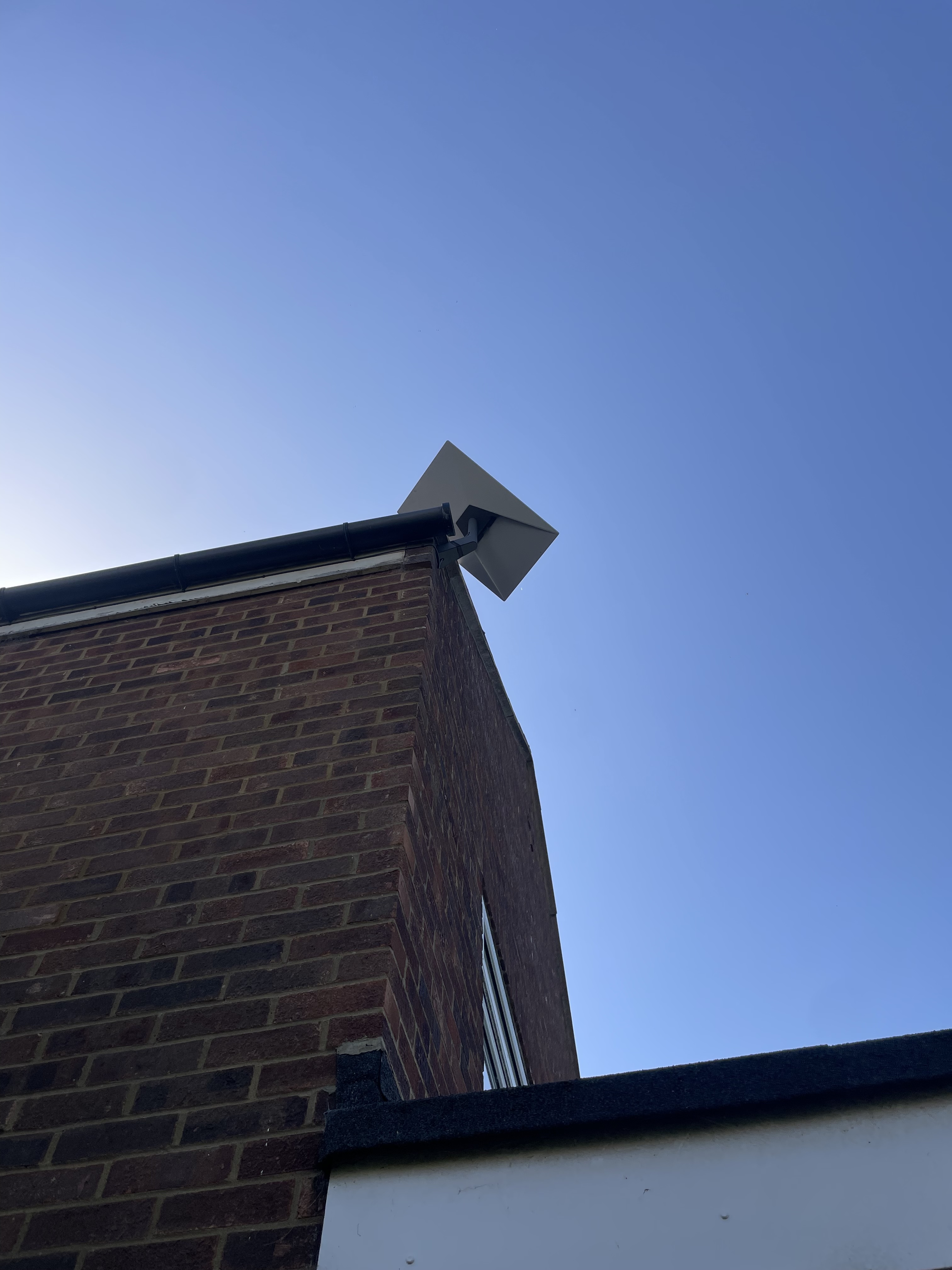Low-profile Starlink mount at the corner of a brick house