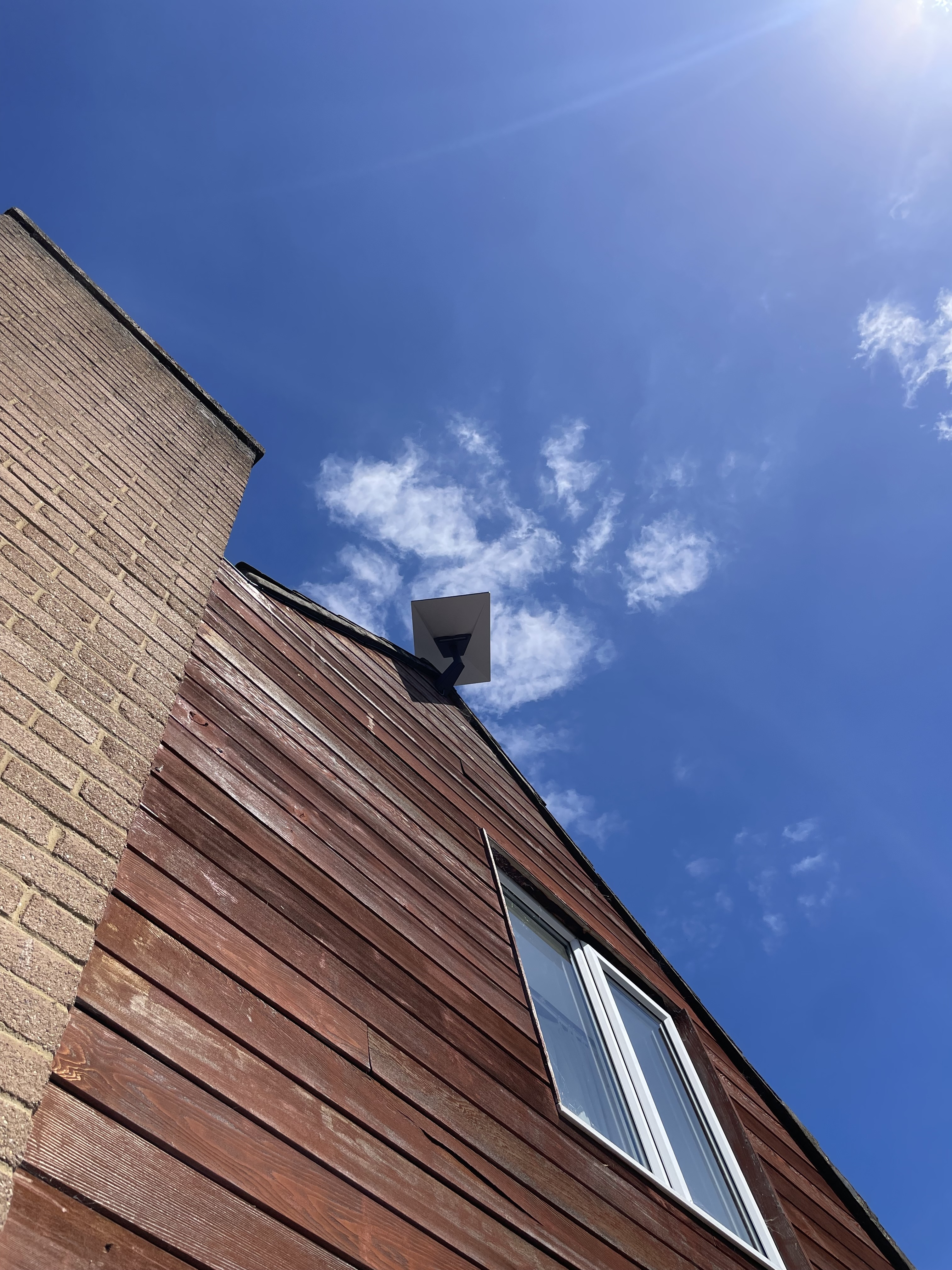 Starlink dish installed high on a timber-clad gable